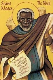 An icon of St. Moses the Black holding a scroll and a bag of sand on his back.