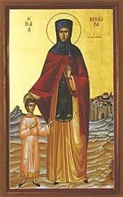 An icon of St. Theodora standing next to a young boy with her hand on his head.